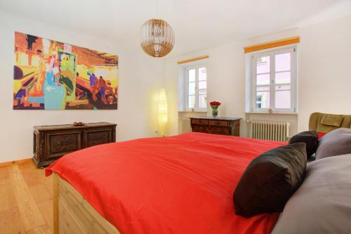 sypialnia z czerwonym łóżkiem i obrazem na ścianie w obiekcie Ferienwohnung Am Alten Rathaus w mieście Neustadt an der Weinstraße