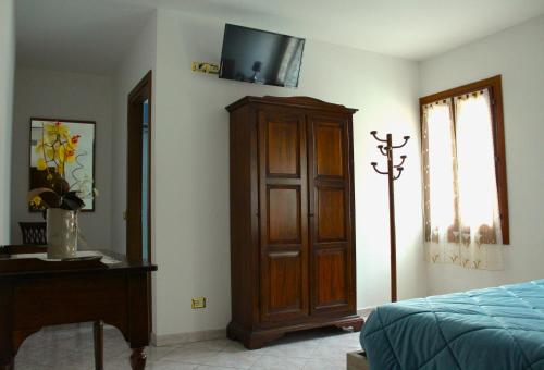 a bedroom with a bed and a cabinet and a window at Locanda della Pescheria in Comacchio