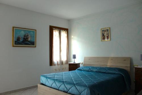 a bedroom with a blue bed and a window at Locanda della Pescheria in Comacchio