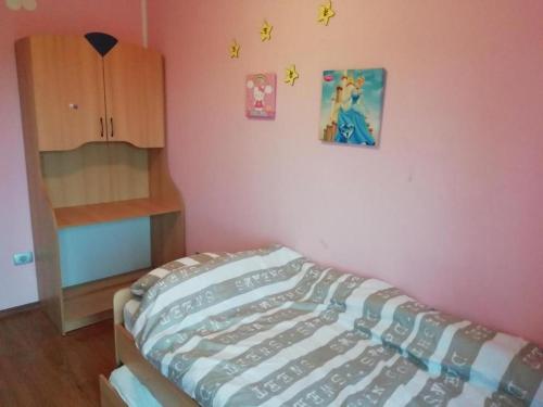 ein Schlafzimmer mit einem Bett und einer rosa Wand in der Unterkunft RTL 2 in Koper