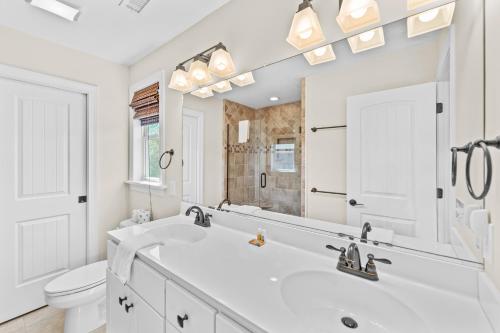 a white bathroom with a sink and a toilet at Killin' Time in Kill Devil Hills