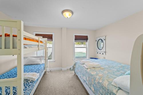 a bedroom with two bunk beds and a ladder at Killin' Time in Kill Devil Hills