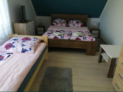a bedroom with two beds and a table at Pokoje u Izy Stare Kiejkuty in Szczytno