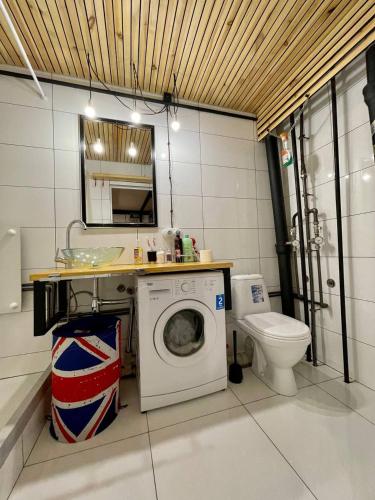 ein Badezimmer mit Waschmaschine und Toilette in der Unterkunft Стильная студия на Арбате золотой квадрат пересечение Абылай хана - Жибек Жолы in Almaty