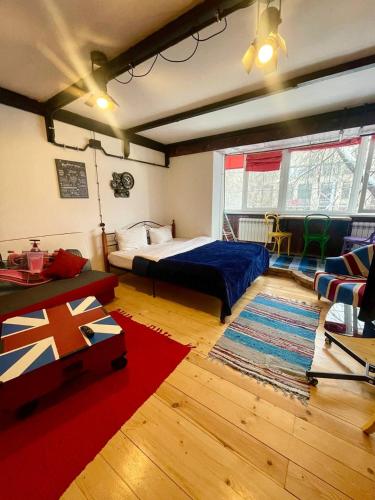 ein Schlafzimmer mit einem Bett, einem Sofa und einem Teppich in der Unterkunft Стильная студия на Арбате золотой квадрат пересечение Абылай хана - Жибек Жолы in Almaty