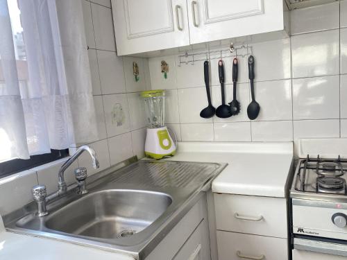 a kitchen with a sink and a counter with utensils at La Dehesa House in Santiago