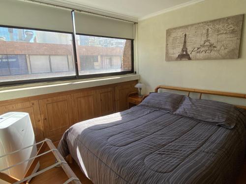 1 dormitorio con 1 cama y 2 ventanas en La Dehesa House en Santiago