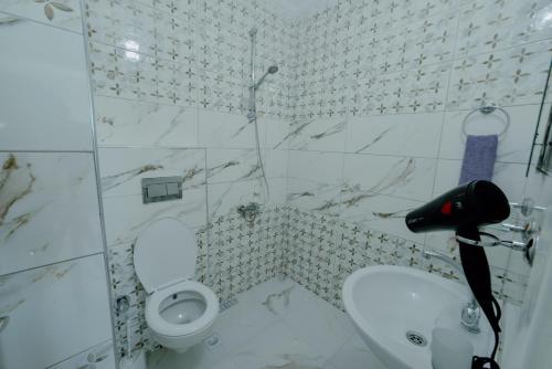 a white bathroom with a toilet and a sink at EMİSSA MOTEL in Akçatepe