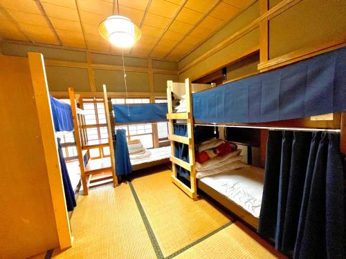 a room with two bunk beds in a room at 自然豊かな隠れ家 ゲストハウス和村Nagomura in Shimonoseki