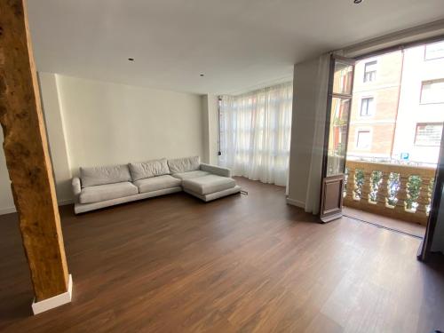 uma sala de estar com um sofá e uma grande janela em Bilbao center apartament em Bilbao