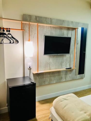 a living room with a flat screen tv and a table at ibis budget Foz do Iguaçu in Foz do Iguaçu