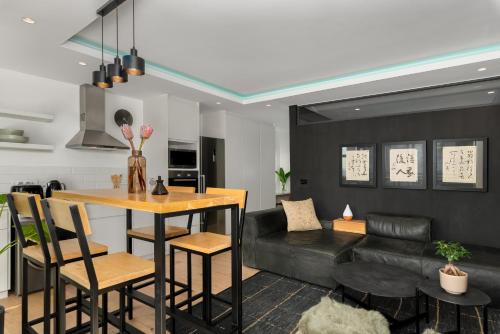 The Iron Works Apartments في كيب تاون: مطبخ وغرفة معيشة مع طاولة وأريكة
