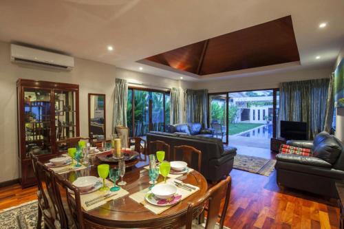 a living room with a wooden table and chairs at Exotic Boutique 4BR Pool Villa Toya, Gated Residence, Rawai in Rawai Beach