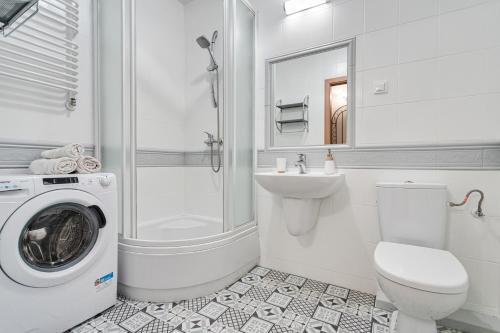 a white bathroom with a washing machine and a sink at Apartament u Andzi in Stegna