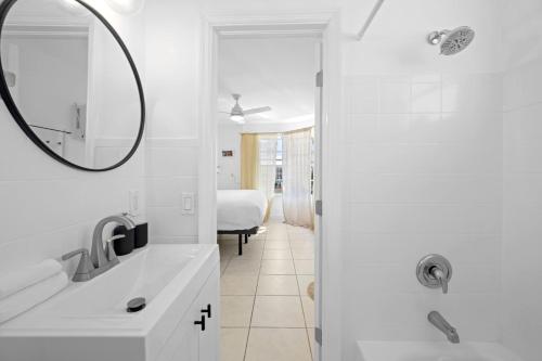 bagno bianco con lavandino e specchio di The Madison South beach Suites a Miami Beach