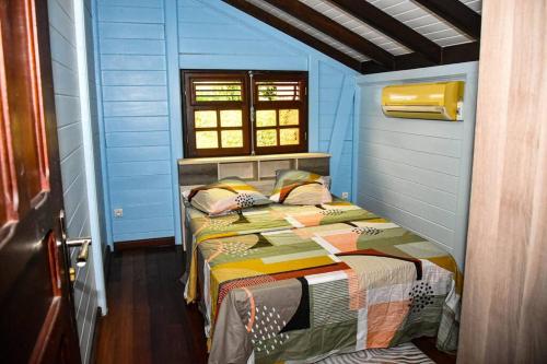 - une chambre avec un lit dans une pièce bleue dans l'établissement Chalet WEITHY, à Bois dʼInde