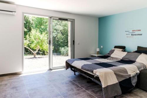 une chambre avec un lit et une grande fenêtre dans l'établissement Studio en pierre U Pinu, 2 personnes, Muratello, 6 Kms de Porto Vecchio, à Porto-Vecchio