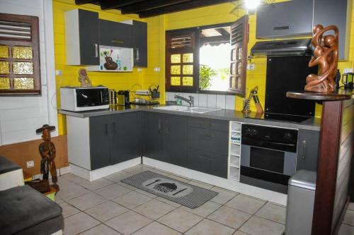 a kitchen with gray cabinets and yellow walls at Chalet WEITHY in Bois dʼInde