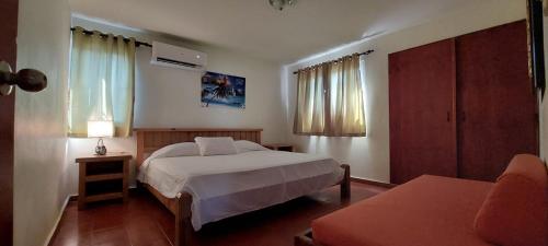 a bedroom with a bed and a couch in a room at Hotel Don Andres in Sosúa