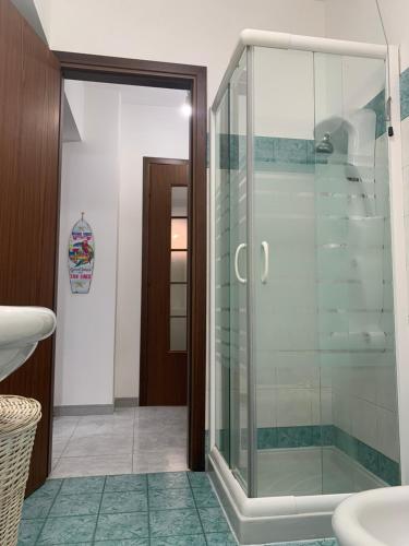 a bathroom with a glass shower and a sink at Torrevarata vacanze in Santa Teresa di Riva