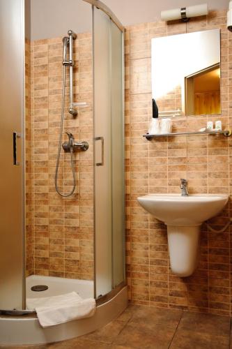 a bathroom with a sink and a shower at Hotel Carskie Koszary in Zamość