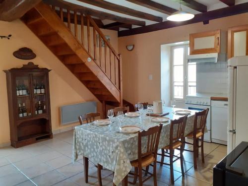 a dining room with a table with chairs and a staircase at Maison rénovée sur domaine viticole Renovated old house on wine estate in Chassey-le-Camp