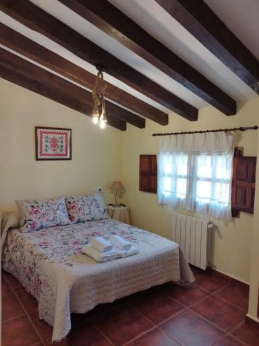 1 dormitorio con cama y ventana en El Humilladero, en Mogarraz