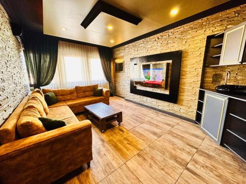 a living room with a couch and a brick wall at GOLDEN ROCK HOUSE in Ankara