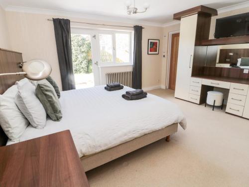 a bedroom with a bed with a desk and a television at The Croft in Alnwick