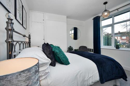 una camera da letto con letto, lenzuola e cuscini bianchi di Cowdray Avenue a Colchester