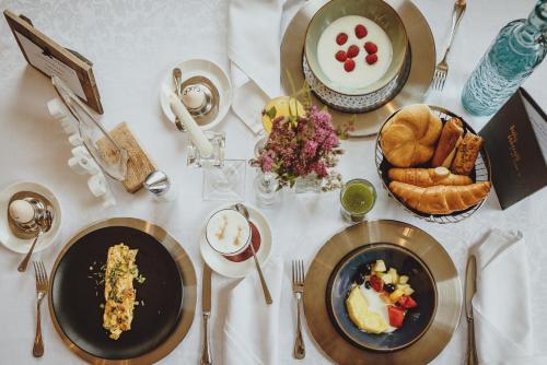a white table with plates of food on it at Superior Sport und Familienresort Alpenblick in Zell am See