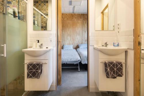 een badkamer met 2 wastafels en een kamer met een bed bij Casona con Jacuzzi in Betanzos
