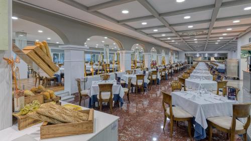 a dining room with white tables and chairs at Playadulce in Aguadulce