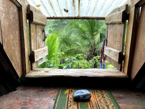 an open window with a view of a garden at Rustic Cabin in Pavones surf brake in Pavones