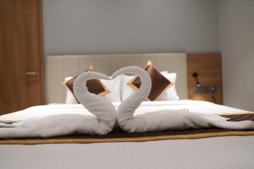 a bed with two swans made to look like a heart at Hotel Grand Alleppey in Alleppey