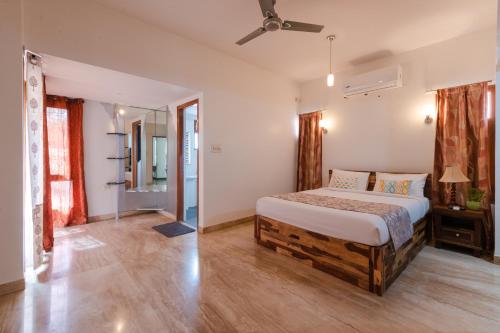 Villa 9C by Revkeys في بانغالور: غرفة نوم بسرير ومروحة سقف