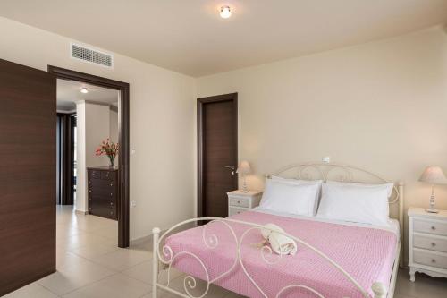 a bedroom with a bed with a pink blanket at Villa Antoni in Galatás