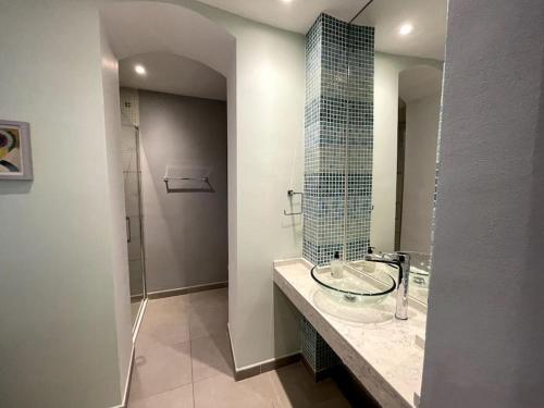 a bathroom with a glass sink and a shower at Stylish 2BR contemporary design perfect vacation in Gibraltar