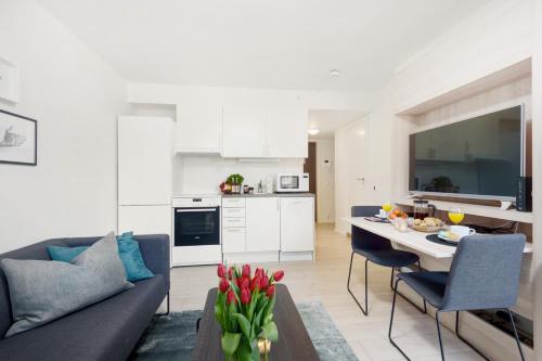 a kitchen and living room with a couch and a table at The Apartments Company - Majorstuen in Oslo
