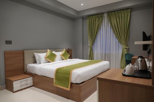 a bedroom with a large bed and a window at Hotel Grand Alleppey in Alleppey