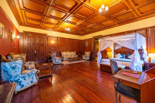 a large living room with a bed and chairs at Muthu Sovereign Suites & Spa, Limuru Road, Nairobi in Limuru