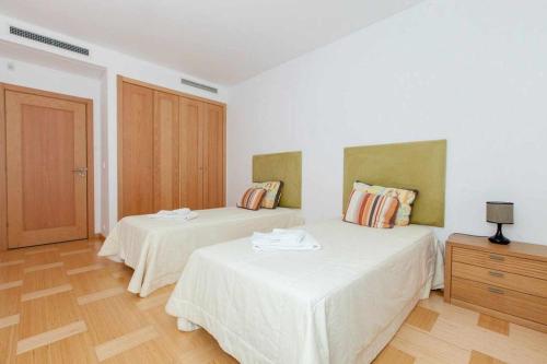 ヴィラモウラにあるMarina Vilamoura Aquamar 315 by Vilamoura Sunのベッドルーム1室(ベッド2台付)が備わります。