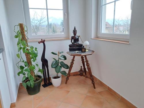 una habitación con una mesa con una estatua y una planta en Casa Sandra en Villach