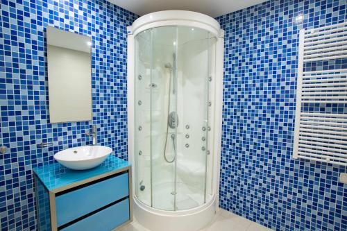 a blue tiled bathroom with a shower and a sink at Marina Vilamoura Aquamar 215 VilamouraSun in Vilamoura
