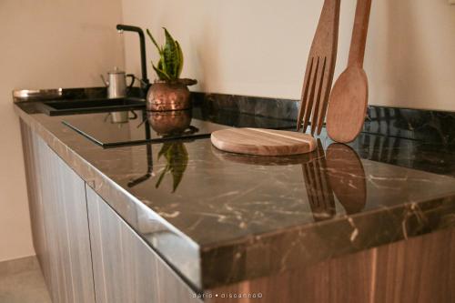 a kitchen with a counter with two wooden utensils at Casa Ferretti apartment in Brindisi