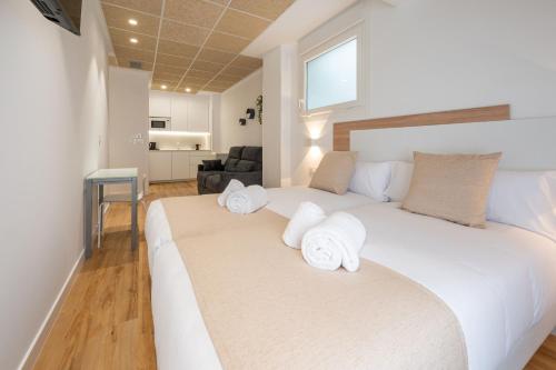 1 dormitorio con 1 cama blanca grande y toallas. en Elegant Rooms Lasarte, en Lasarte