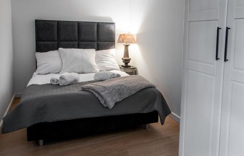 1 dormitorio con 1 cama grande y cabecero negro en Apartamenty przy plaży, en Jastarnia