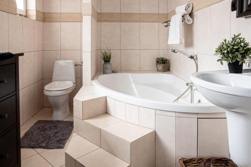 a bathroom with a tub and a toilet and a sink at Apartamenty przy plaży in Jastarnia