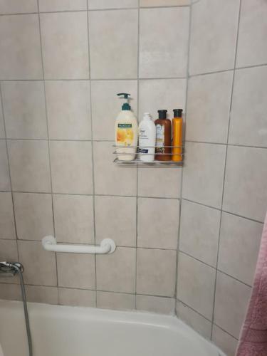 a bathroom with bottles of soap and a bath tub at Amazing Apartment in Raanana & Swimming up to 4 guests pool and Jacuzzi in Ra‘ananna