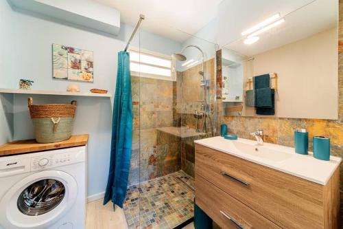 a bathroom with a sink and a washing machine at L'étoile du Sud in Saint-Pierre